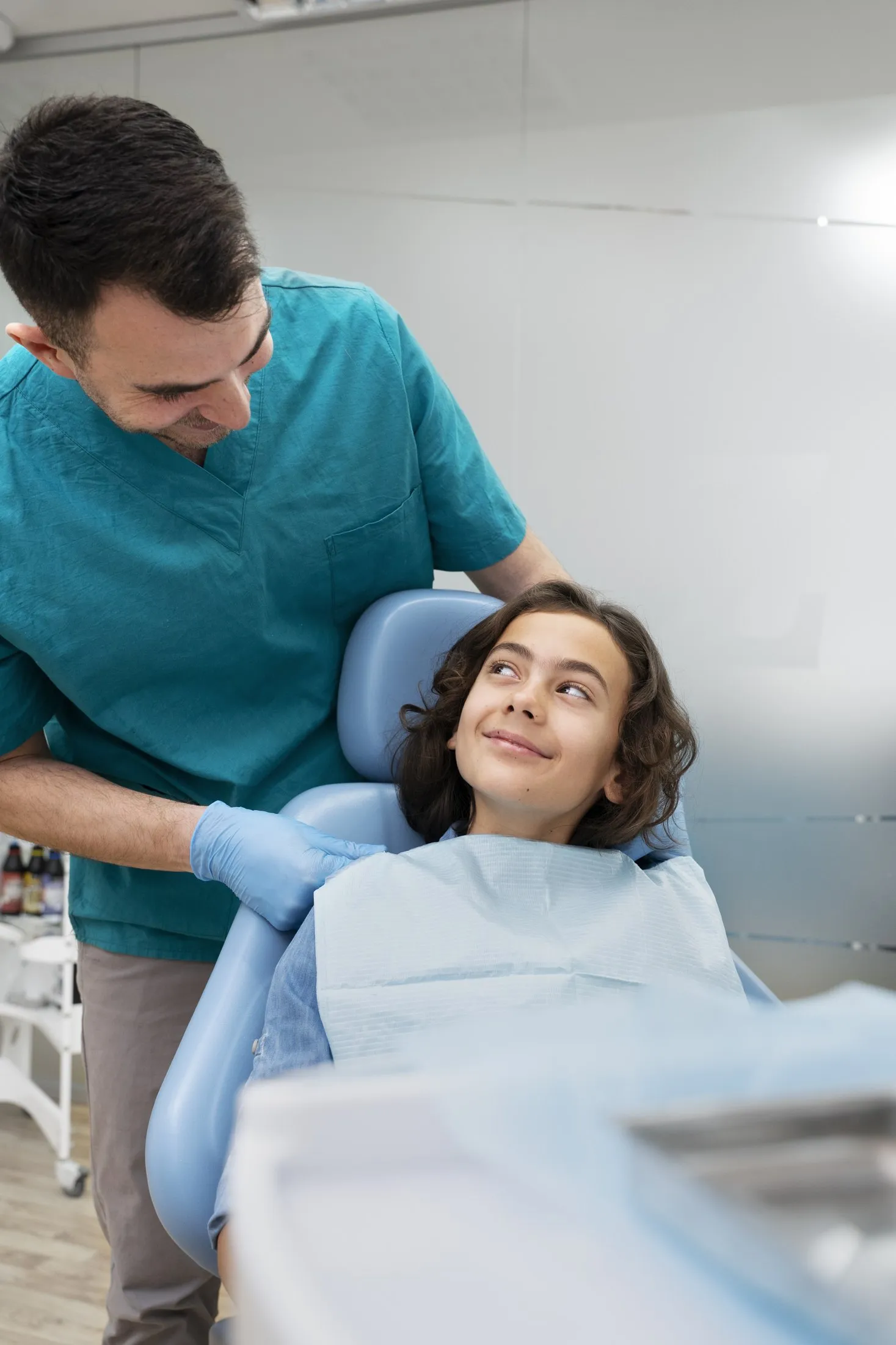 Criança sorrindo na cadeira do dentista durante a consulta